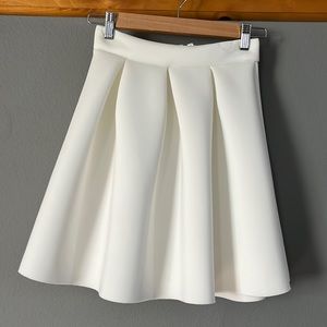Large pleaded white A-line skirt